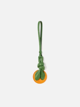 Der orangefarbene, orangeförmige Taschenanhänger mit Knoten